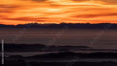 Fototapeta Naklejka Na Ścianę i Meble -  Inversion in the valley during sunrise with mountain ridge in the background.