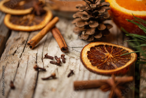 Winter Christmas composition with spruce cone, dried orange and spices on wooden background. Festive wallpaper. Idea for decoration. Close-up.