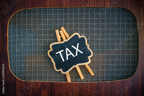 Tax word concept over wooden background