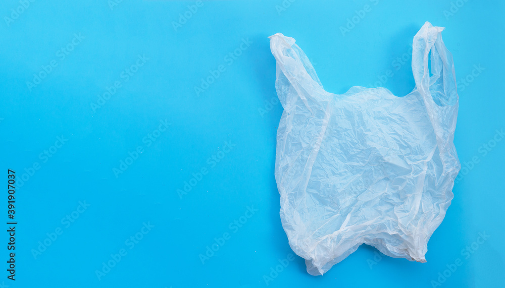 Fototapeta premium White plastic bag on blue background. Copy space