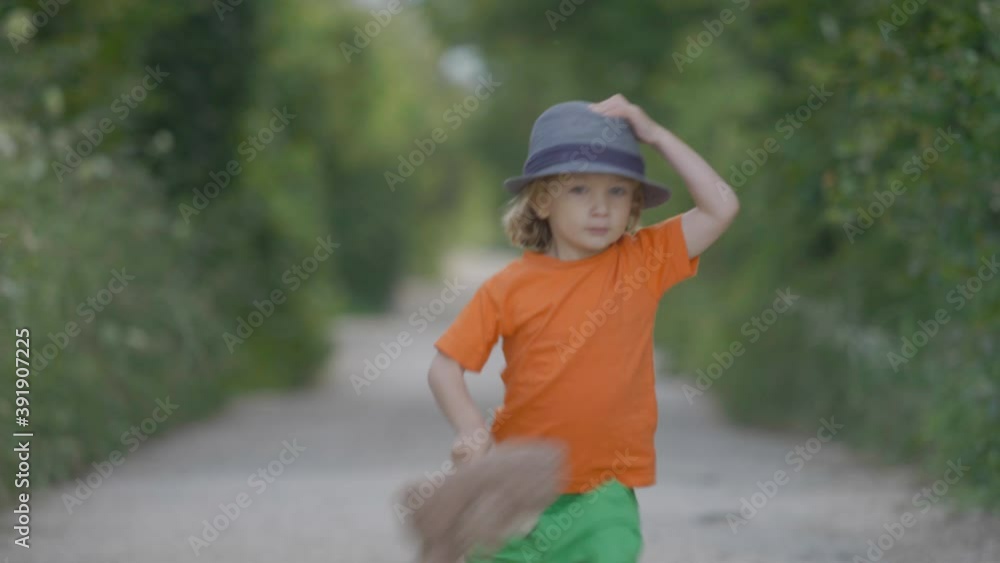 funny little child with hat holding a teddy bear running on empty village road funny little child with hat holding a teddy bear running on empty village road