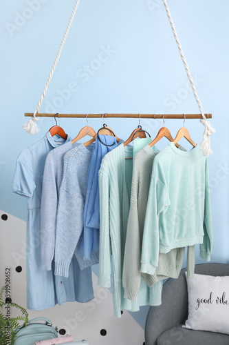 Rack with autumn clothes in interior of modern room © Pixel-Shot