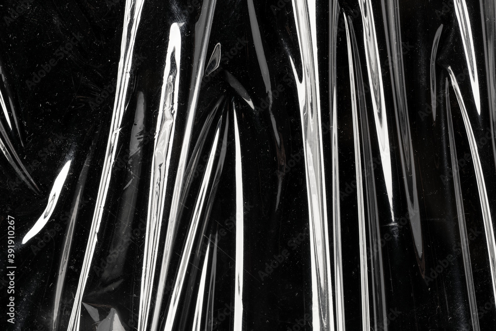 Fotografie Wrinkled plastic wrap texture on a black background wallpaper