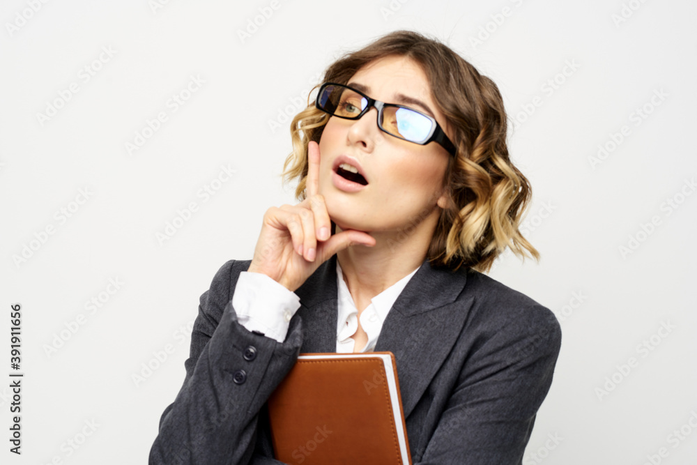 Business woman with notepad and glasses work light background cropped view of suit model. Business woman with notepad and glasses work light background cropped view of suit model.