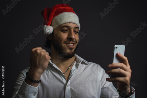 hombre caucásico recibiendo una buena noticia en navidad a través de su teléfono móvil  photo