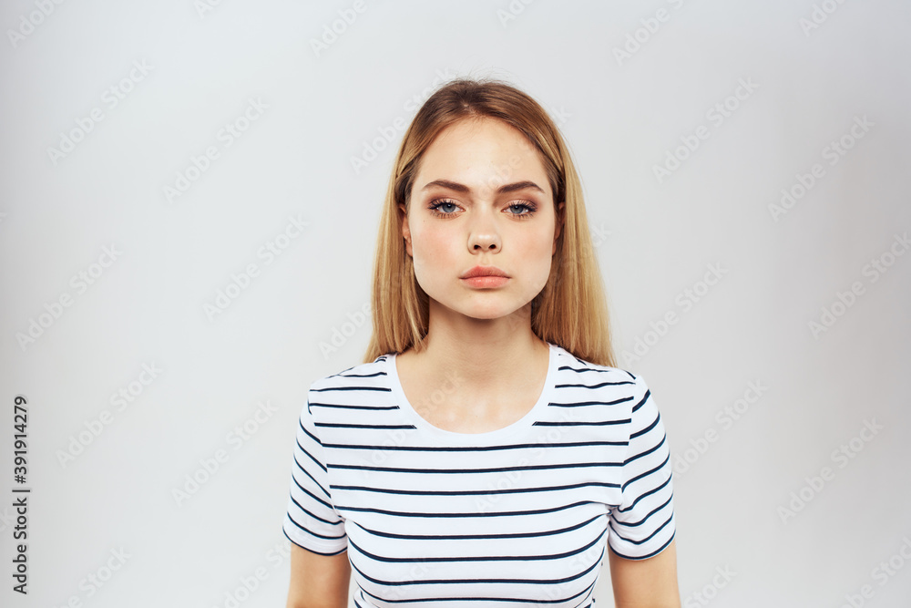 Fototapeta premium emotional woman in striped t-shirt gesture with hands lifestyle light background