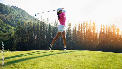 happy and cheerful of the woman golf player in winning putt a ball completed into the hole on the green