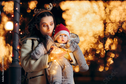 Funny Mom and Baby Holding Christmas Lights Celebrating Outdoors