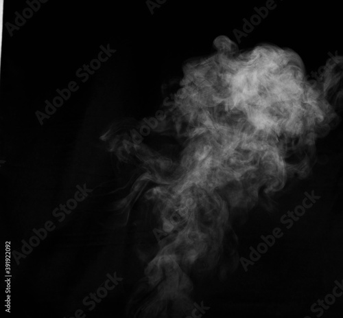 White smoke on black background. Figured smoke on a dark background. Abstract background, design element