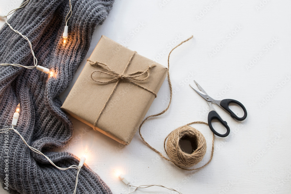 gift box for special in christmas and happy new year festival with rope ,scissors knitting wool scarf in winter season arrangement flat lay style on background white wooden gift box for special in christmas and happy new year festival with rope ,scissors knitting wool scarf in winter season arrangement flat lay style on background white wooden