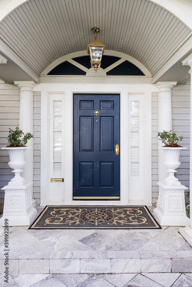 entrance to the house with a dark blue front door Photos | Adobe Stock