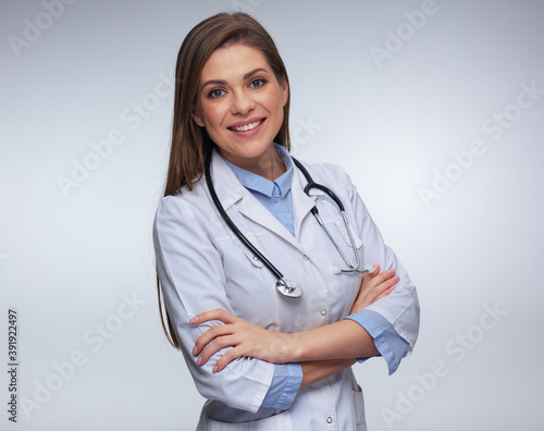 Woman doctor dressed white uniform posing with crossed arms.