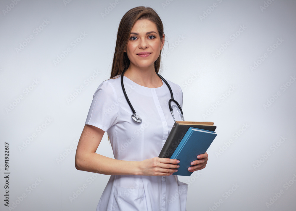 Smiling woman doctor holding books or medical journal Smiling woman doctor holding books or medical journal