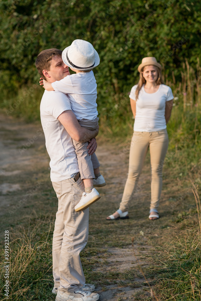 Happy family enjoying walk together at meadow in summer Happy family enjoying walk together at meadow in summer