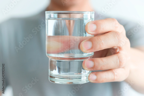 In the Morning, hand of man holding a clear glass of water for drinking.