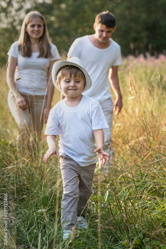 Happy family enjoying walk together at meadow in summer