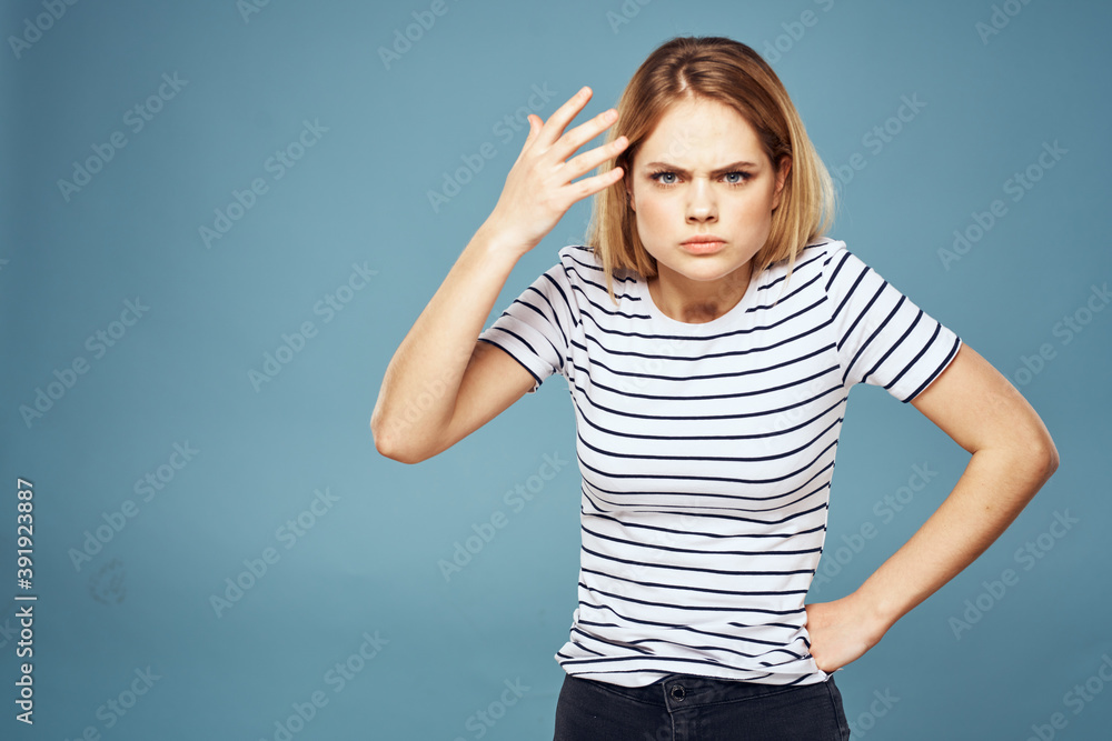 Fototapeta premium Upset woman emotions displeasure gestures with hands blue background
