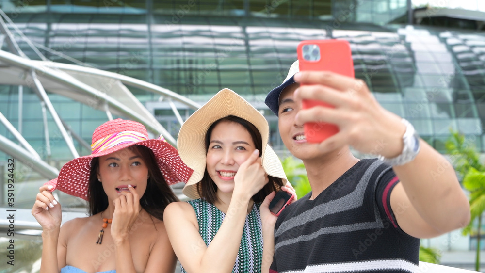 Three asian young friends enjoy outdoor time taking selfies in the city