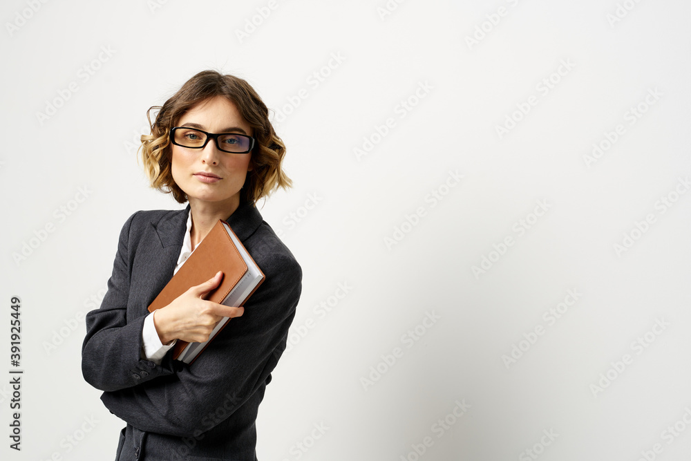 Woman at work with book in hand light background classic suit glasses head Woman at work with book in hand light background classic suit glasses head