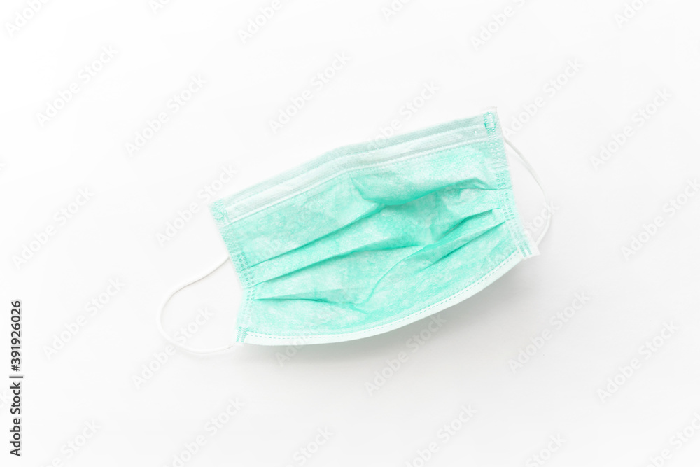 Surgical mask with rubber ear straps isolated on white background. White mask to cover the mouth and nose. Surgical mask with rubber ear straps isolated on white background. White mask to cover the mouth and nose.