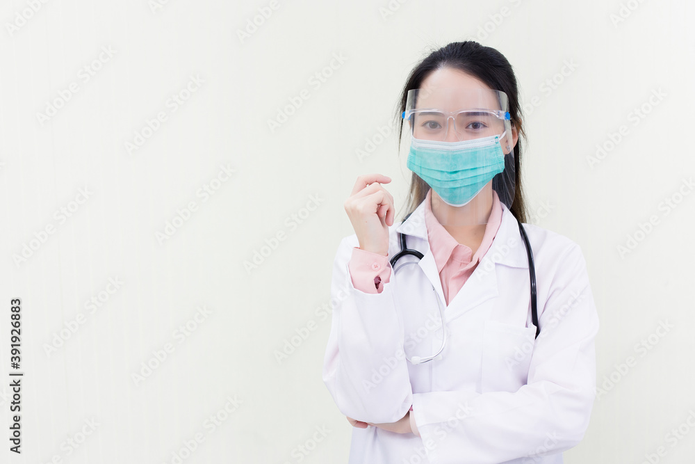 Asian woman doctor wears medical face mask and face shield to protect Coronavirus (Covid 19) or pathogen in health care concept and shows hand up on white background. Asian woman doctor wears medical face mask and face shield to protect Coronavirus (Covid 19) or pathogen in health care concept and shows hand up on white background.
