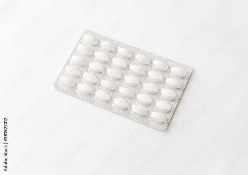 White pills tablets in package on a white background. Capsule pills in plastic pack for pharmacy and medicine. White pills tablets in package on a white background. Capsule pills in plastic pack for pharmacy and medicine.