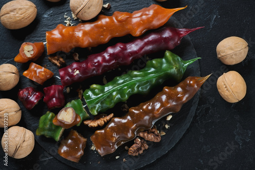 Top view of sliced georgian traditional churchelas on a stone slate tray, studio shot over black stone surface photo