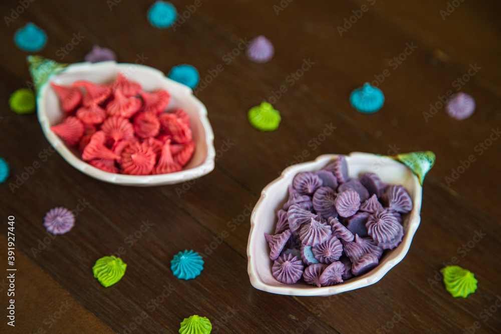 Close up red and purple homemade Allure Thai candy in a mini bowl on a rustic wooden table, Allure is traditional Thai desserts sweet and delicious. Close up red and purple homemade Allure Thai candy in a mini bowl on a rustic wooden table, Allure is traditional Thai desserts sweet and delicious.