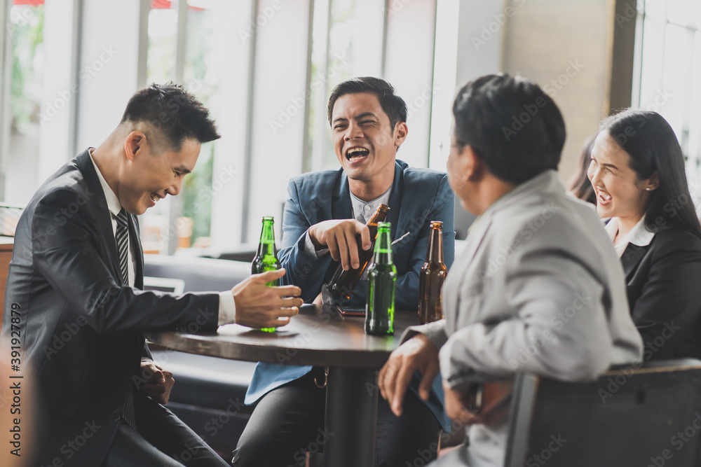 Obraz premium Group Of Asian Friends Enjoying Evening Drinks in bar. Celebration, Party People Christmas and Happy new year concept. Asian business people in party.
