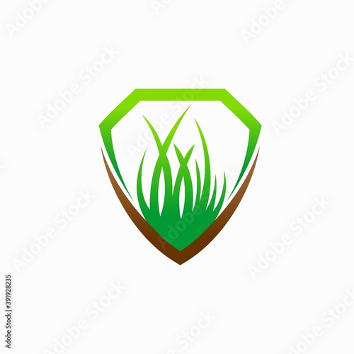 shield logo with green grass