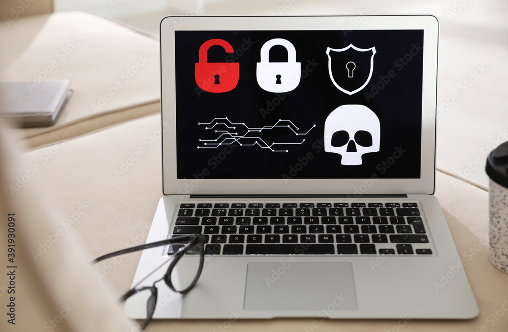 Glasses and laptop with virus illustration on beige sofa Glasses and laptop with virus illustration on beige sofa