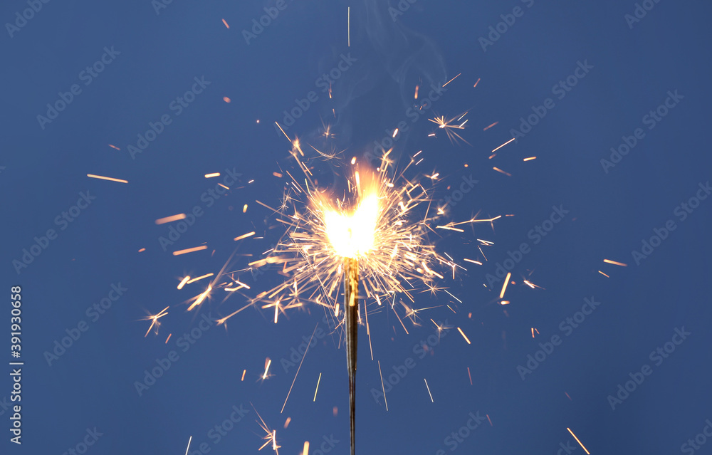 Obraz premium Beautiful sparklers burning on blue background. Party decor