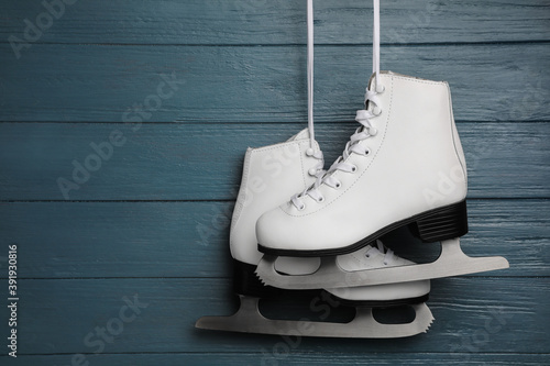 Canvas Print Pair of white ice skates hanging on blue wooden background
