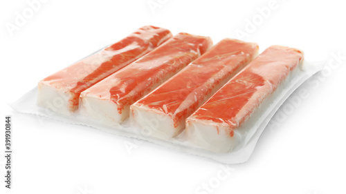 Delicious crab sticks in plastic packaging isolated on white