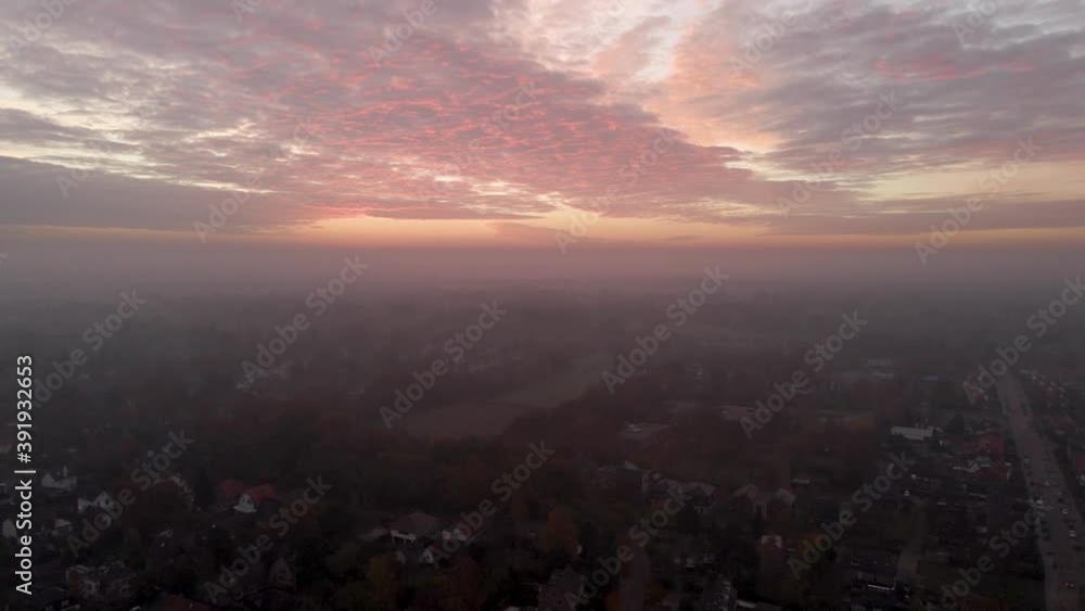 High jib up of sun rising over a small town covered in fog High jib up of sun rising over a small town covered in fog