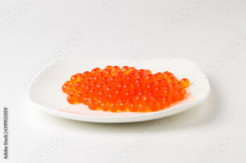 Red caviar on a white plate. Source of fat, protein, and carbohydrates.