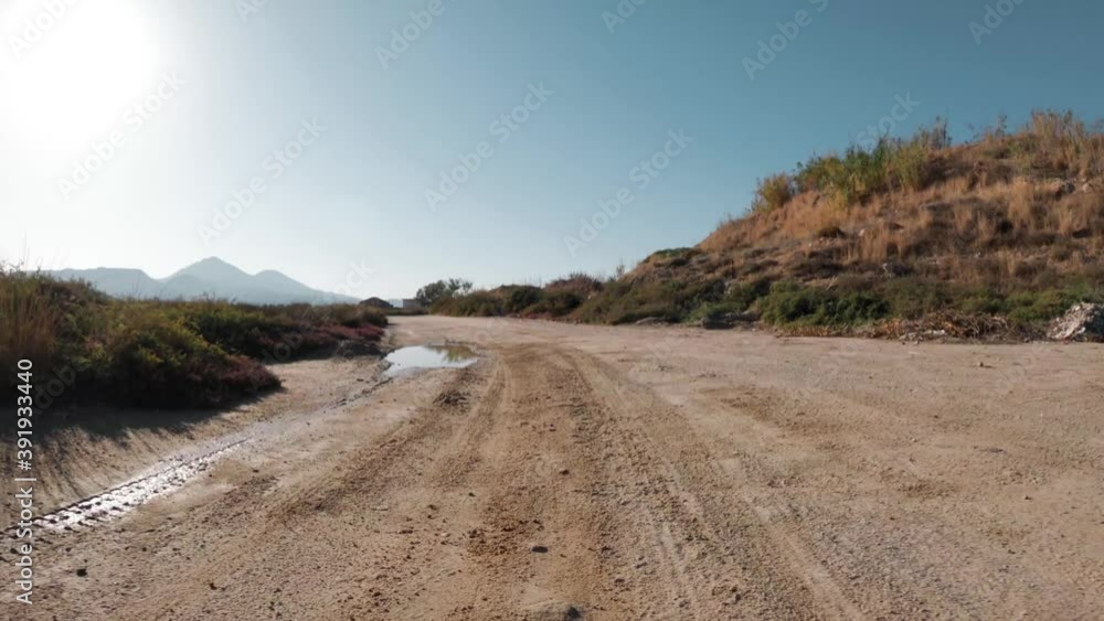 A 4wd car driving on a harsh dirt road and splashing water. Front bumper pov A 4wd car driving on a harsh dirt road and splashing water. Front bumper pov