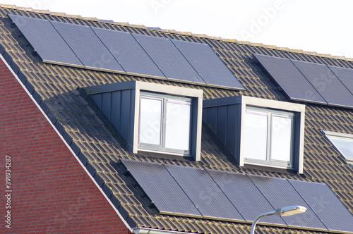 Billede på lærred Solar panels on a brown roof with dormer for electric power generation