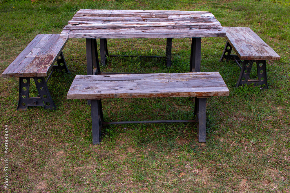 A wooden picnic bench used for eating outdoor. Park bench for recreation.