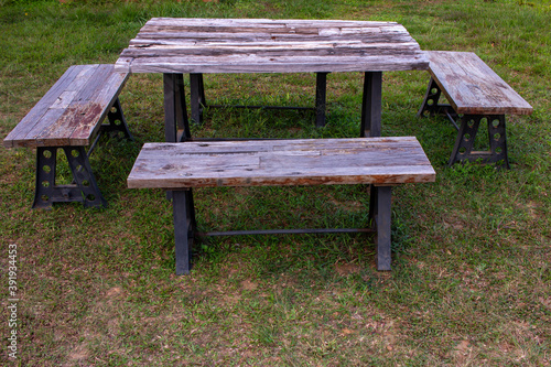 A wooden picnic bench used for eating outdoor. Park bench for recreation.