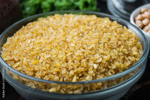 Bulgur grain on dark wooden background