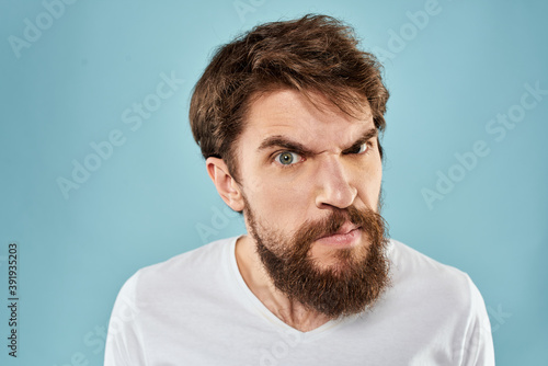 Bearded man emotions facial expression gestures hands close-up blue background