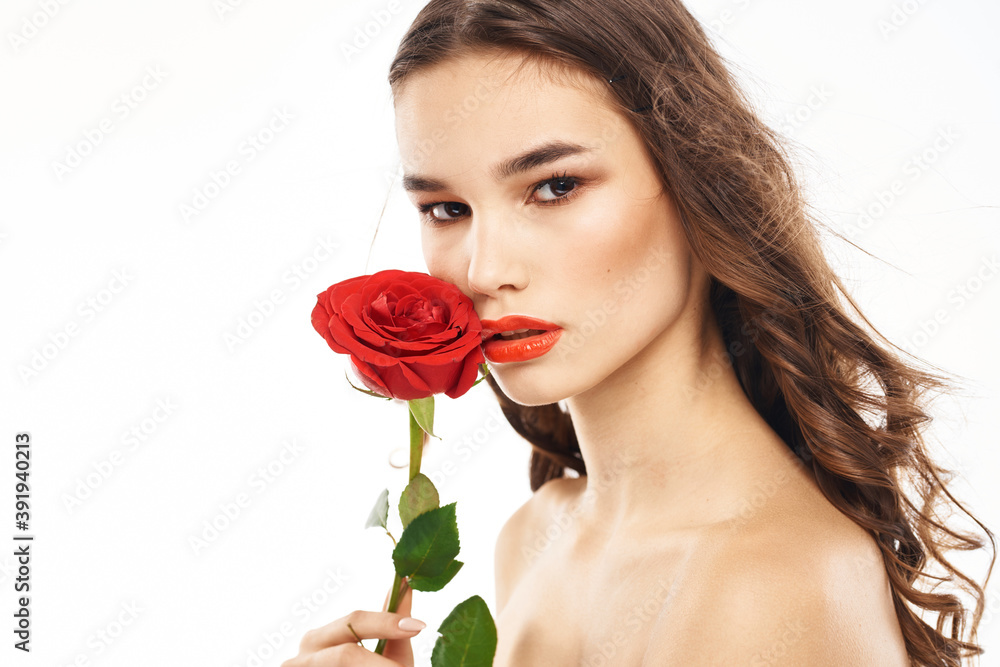 Woman with naked shoulders and red rose evening makeup light background Woman with naked shoulders and red rose evening makeup light background