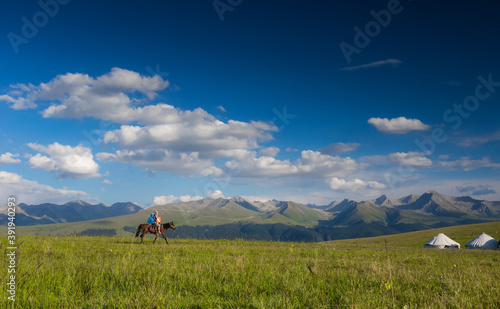 Travel shooting, father and son riding a horse on the grassland, beautiful grassland scenery