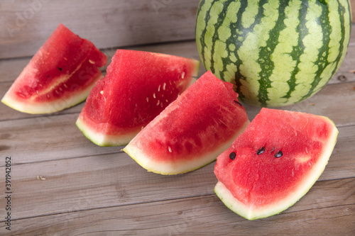 A green-skin watermelon and a few sliced watermelons