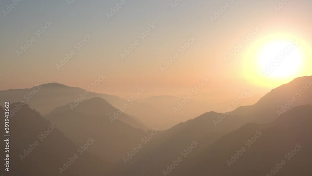 Panning drone shot of an epic sunset over the hazy Angeles Mountains north of Los Angeles, California. Panning drone shot of an epic sunset over the hazy Angeles Mountains north of Los Angeles, California.