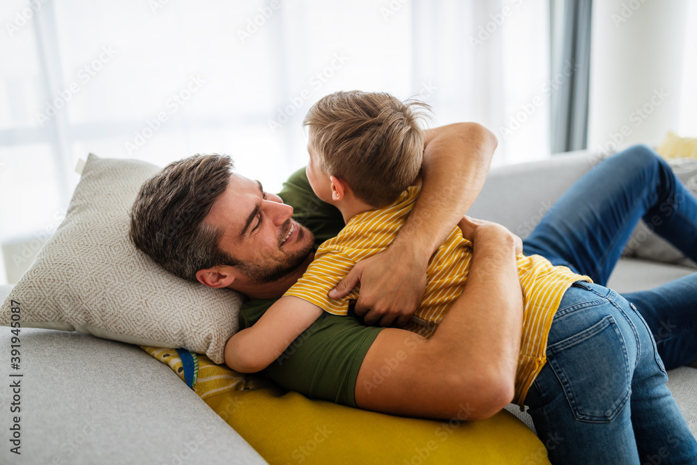 Happy father and son are smiling while spending time together at home Happy father and son are smiling while spending time together at home