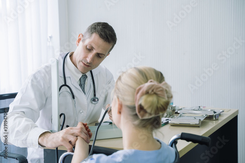 Doctor use stethoscope to check heart rate and pressure gauge for young female patient and explain medical treatments in examination room at hospital.
