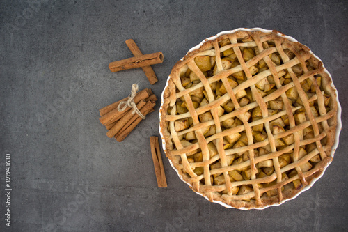 Apple pie with cinnamon  on a table. Gray background with copy space. Healthy eating concept. 