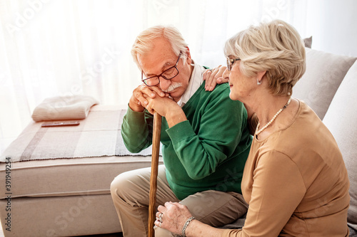Portrait of woman hugging senior husband with walking stick at home. Shot of a senior woman comforting her husband. Always supporting one another